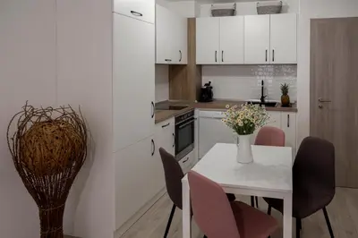 a white kitchen with a white table and chairs at SOS CoMFORT in Burgas City