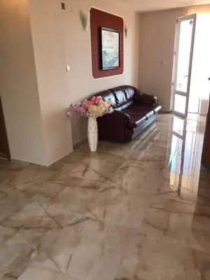 a living room with a couch and flowers in a vase at Hotel PERLA BEACH in Sozopol