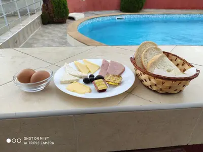 a plate of cheese and bread and a basket of eggs at Hotel PERLA BEACH in Sozopol