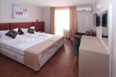 a hotel room with a bed and a television at Hotel PERLA BEACH in Sozopol