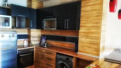a kitchen with black cabinets and a sink and a dishwasher at VIP Sunrise Apartment in Lozenets