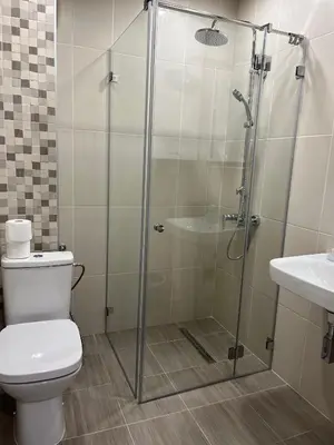 a bathroom with a shower with a toilet and a sink at Kati apartments in Varna City