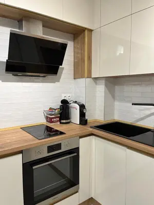 a kitchen with white cabinets and a stove top oven at Kati apartments in Varna City