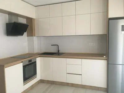 a kitchen with white cabinets and a sink and a refrigerator at Kati apartments in Varna City