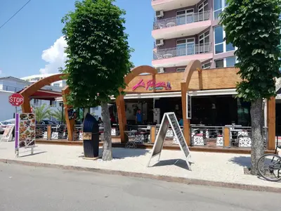 a store on the side of a street with a stop sign at Debbies 2 bed apart with pool and garden views in Sunny Beach