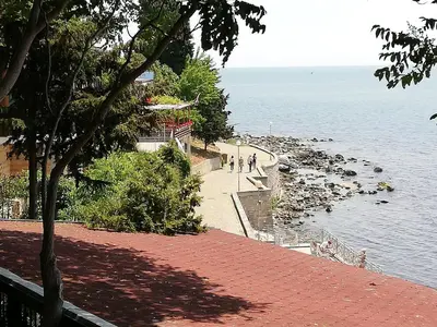 a brick walkway next to a body of water at Debbies 2 bed apart with pool and garden views in Sunny Beach