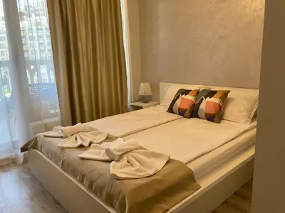 a bedroom with a bed with towels on it at Blue Lagoon Seafront Apartments in Varna City