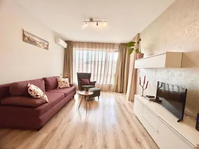 a living room with a couch and a tv at Blue Lagoon Seafront Apartments in Varna City