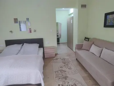 a living room with a bed and a couch at Къща за гости АКАЦИЯ in Ravna Gora