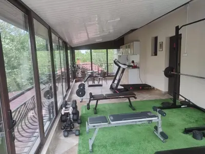 a gym with treadmills and exercise equipment on a balcony at Къща за гости АКАЦИЯ in Ravna Gora