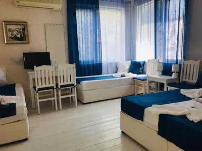 a bedroom with two beds and a table and chairs at Къща Наде in Tsarevo