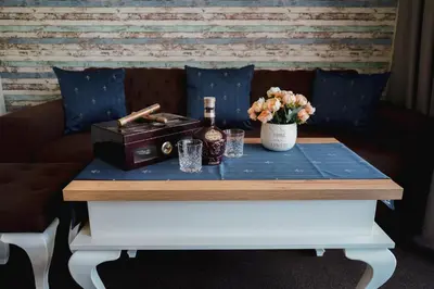 a table with a bottle of wine and flowers on it at Sunny Apartments Obzor in Obzor