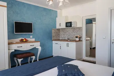 a room with a bed and a kitchen with a tv at Sunny Apartments Obzor in Obzor