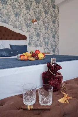 a table with two glasses and a bottle on a bed at Sunny Apartments Obzor in Obzor
