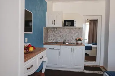 a kitchen with white cabinets and a sink at Sunny Apartments Obzor in Obzor