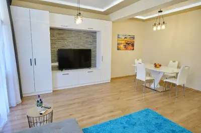 a living room with a table and a tv at Luxury Nevena Apartment - Bogoridi super centre in Burgas City
