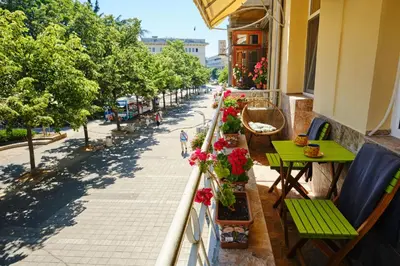 a balcony with tables and flowers on a street at Luxury Nevena Apartment - Bogoridi super centre in Burgas City
