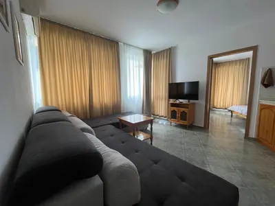 a living room with a couch and a television at Апартамент Одеса 22 in Sozopol