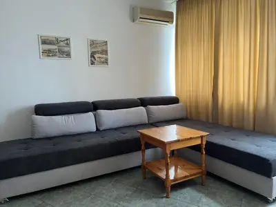 a couch sitting in a room with a table at Апартамент Одеса 22 in Sozopol