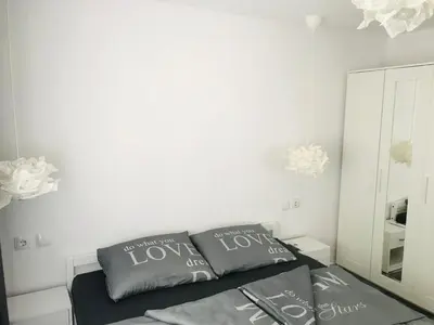 a bedroom with white walls and a bed with two pillows at Вила ОмниЯ in Chernomorets