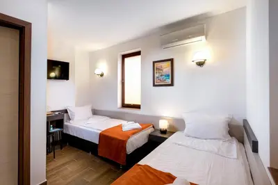 a hotel room with two beds and a window at Panorama Blue Family Hotel and Free parking in Nesebar