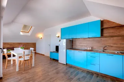 a kitchen with blue cabinets and a dining table at Panorama Blue Family Hotel and Free parking in Nesebar
