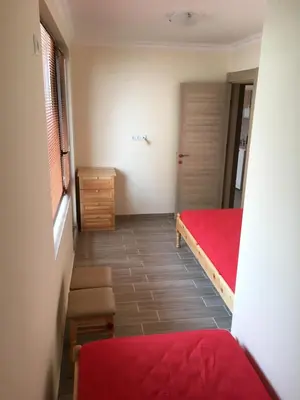 a small room with a red bed and a window at Rent Apartments Martin Beach in Pomorie