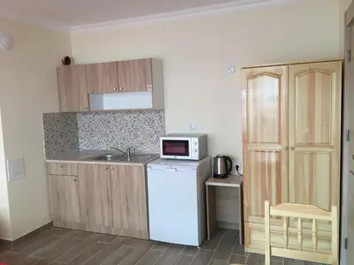 a small kitchen with a white refrigerator and a microwave at Rent Apartments Martin Beach in Pomorie