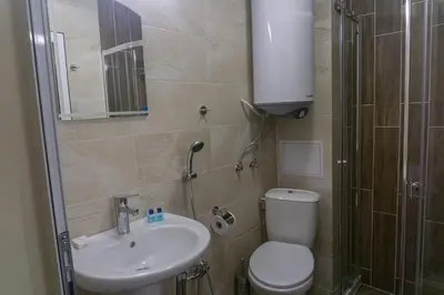 a bathroom with a toilet and a sink and a shower at Rent Apartments Martin Beach in Pomorie