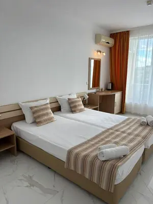 a bedroom with a large bed in a room at ТРОПИКАНА in Primorsko