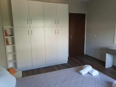 a bedroom with white cabinets and a bed with two towels at Danny apartment in Burgas City