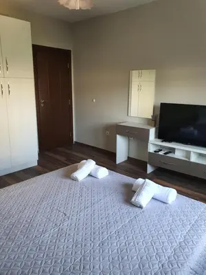 a bedroom with a bed with two pillows and a flat screen tv at Danny apartment in Burgas City