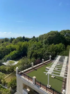 a view of a building with a field of grass at Private Apartments by the sea with a large terrace in Apart hotel! in Pomorie