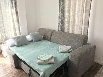 a living room with a couch with a table at Sunny Shore Burgas Apartment in Burgas City