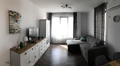 a living room with a couch and a television at Sunny Shore Burgas Apartment in Burgas City