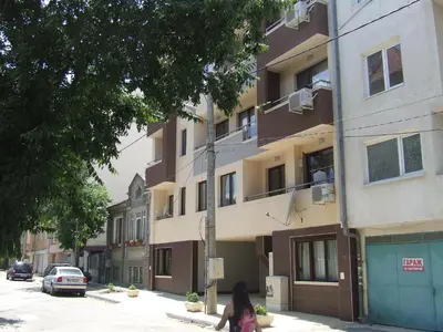 a woman walking down a street in front of a building at Varnaflats Guest Rooms in Varna City