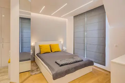 a bedroom with a bed with yellow pillows on it at Deluxe studio Center city in Varna City