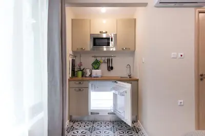 a small kitchen with a refrigerator and a microwave at The Cozy Studio, Varna City Centre in Varna City