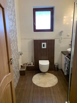 a bathroom with a toilet and a window at Boutique House Belevi in Nesebar