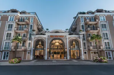 a large building with palm trees in front of it at Dawn Park Deluxe in Sunny Beach