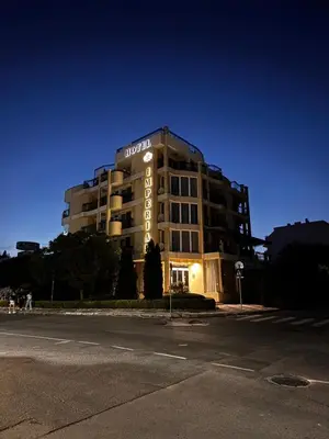 a building with a hotel sign on it at night at Хотел БУТИК ИМПЕРИАЛ in Primorsko