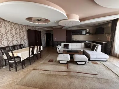a living room with a couch and a table and chairs at Хотел БУТИК ИМПЕРИАЛ in Primorsko
