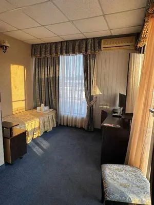 a hotel room with a bed and a window at Хотел БУТИК ИМПЕРИАЛ in Primorsko