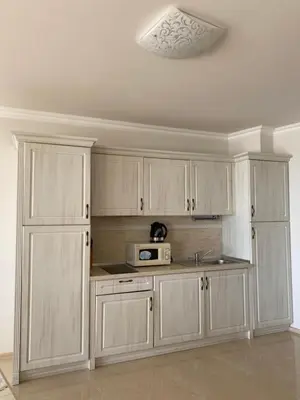 a kitchen with white cabinets and a microwave at Private Super apartments by sea in Apart Hotel ! in Pomorie