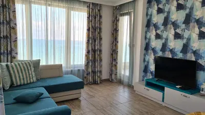 a living room with a couch and a flat screen tv at Villa Flora in Sozopol
