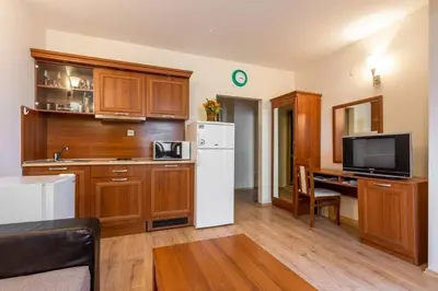 a kitchen with wooden cabinets and a white refrigerator at Avalon appartament da Lary in Sunny Beach