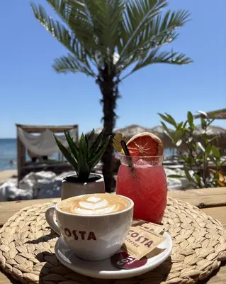 a cup of coffee on a table with a drink at ELIA MARe Hotel ALL Inclusive - Free Beach Access in Kiten