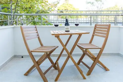 two chairs and a table with two glasses of wine at Comfy home in the heart of Burgas in Burgas City
