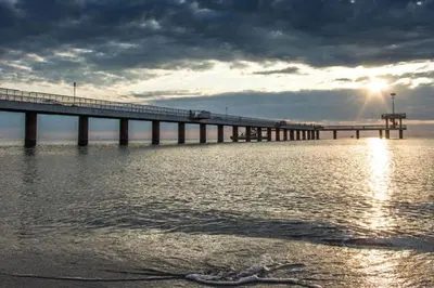 a bridge over a body of water with the sun at Comfy home in the heart of Burgas in Burgas City