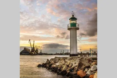 a lighthouse sitting on the rocks next to the water at Comfy home in the heart of Burgas in Burgas City